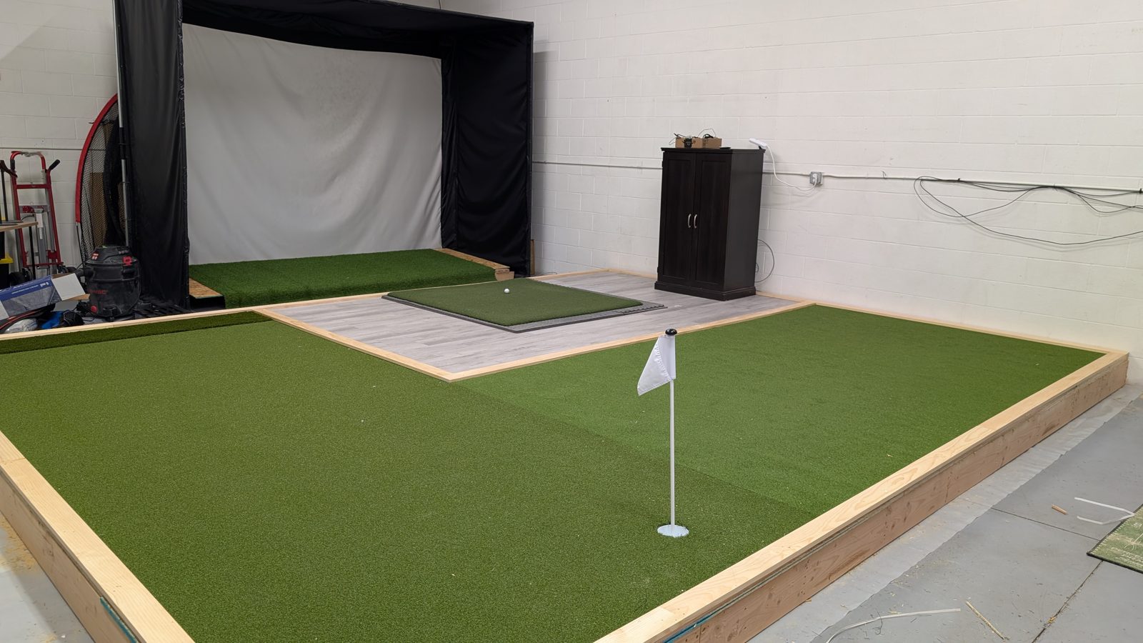 Golf simulator hitting bay with putting green in our Treasure Valley demo space
